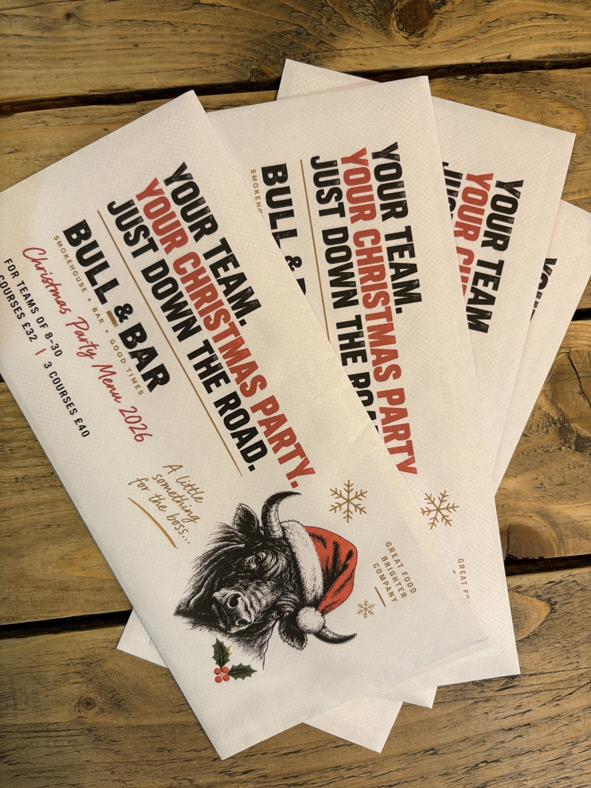 Printed Bull & Bar Christmas Party Menu 2026 leaflets on a wooden table